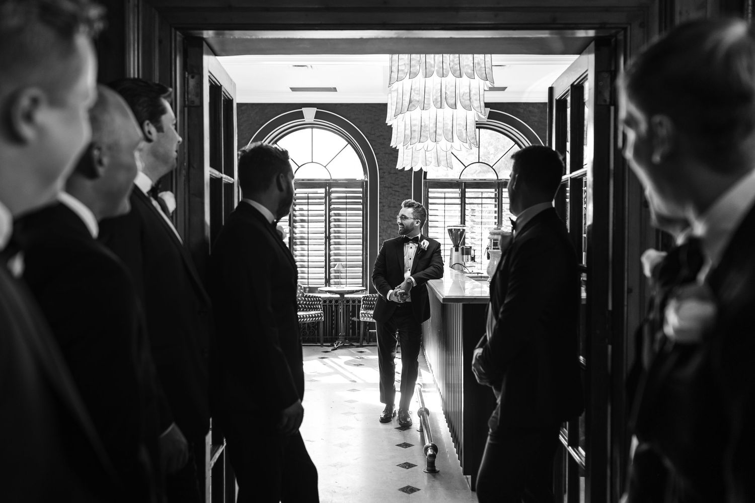 A series of black and white wedding photos showing couples in formal attire standing in elegant indoor venues.