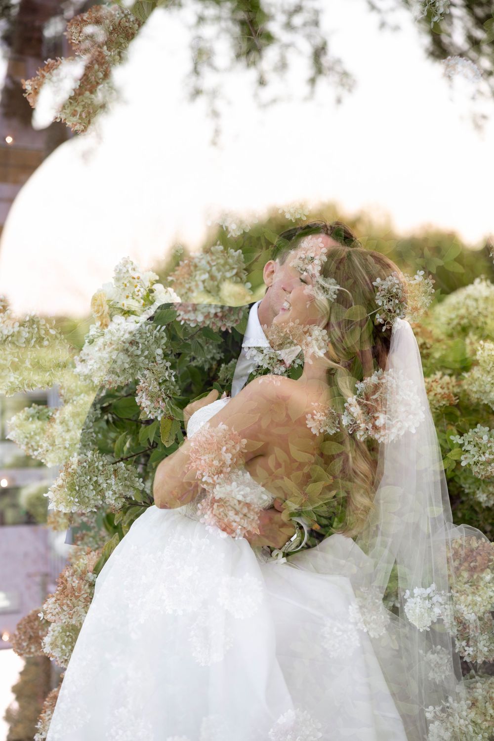 Romantic wedding portraits with delicate white floral arrangements in an outdoor garden.