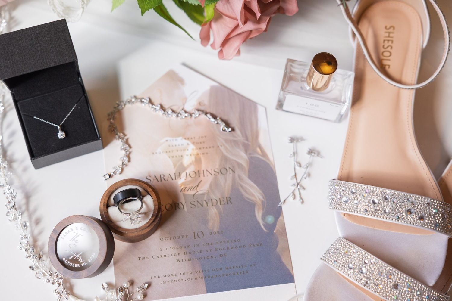 Wedding invitation flat lay with rings, jewelry, and bridal details for a Delaware wedding