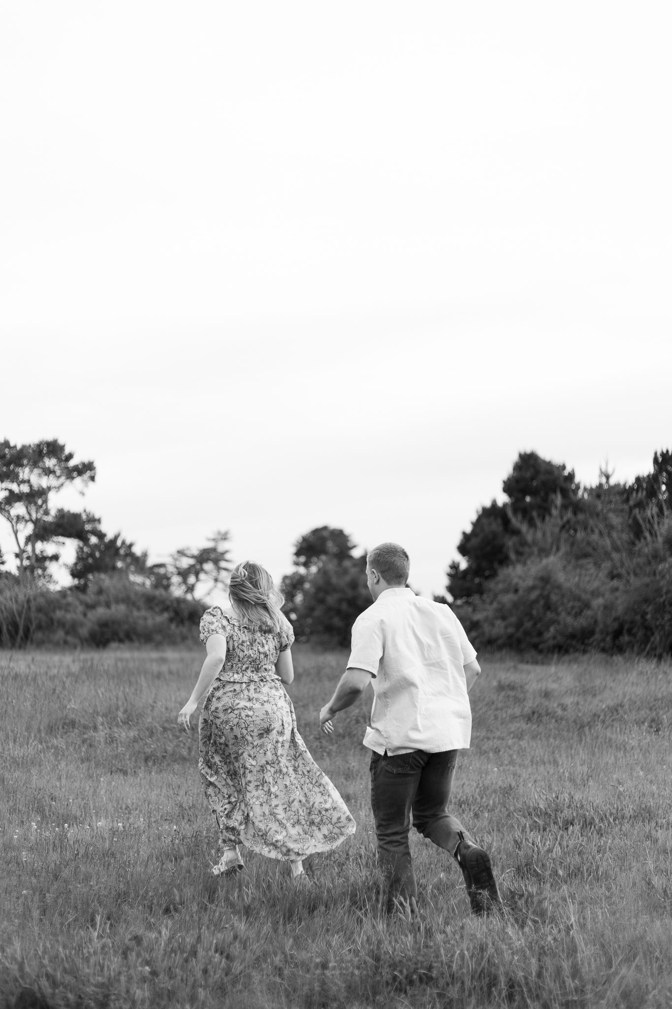A couple dances in a field at sunset, with the woman wearing a flowing lavender lehenga dress that twirls gracefully.