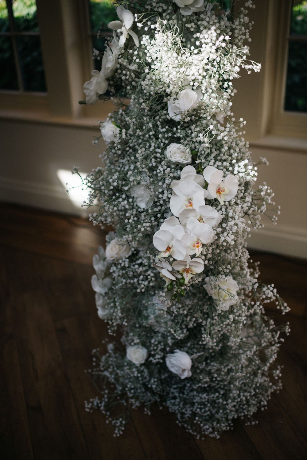 Elegant white floral arrangements with orchids and baby's breath for wedding decor.