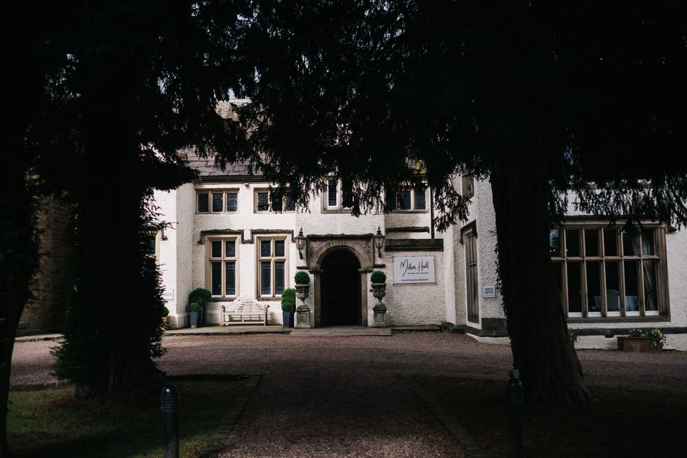 Dark exterior view of a building with trees silhouetted against the sky.