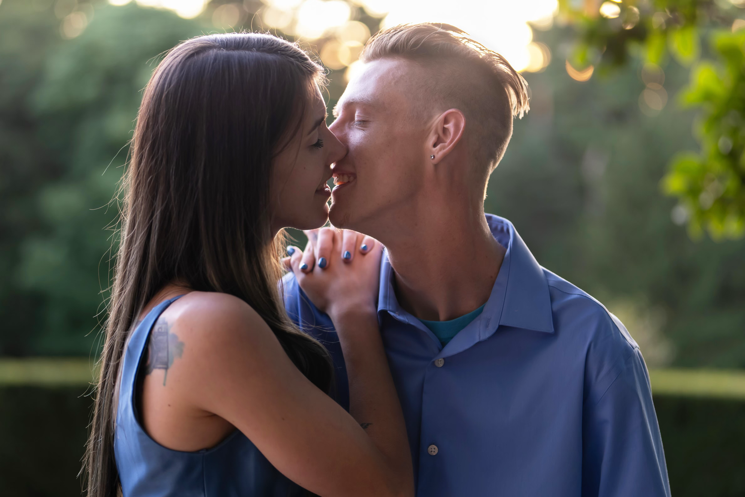 Romantic outdoor engagement photo session showing couple embracing.