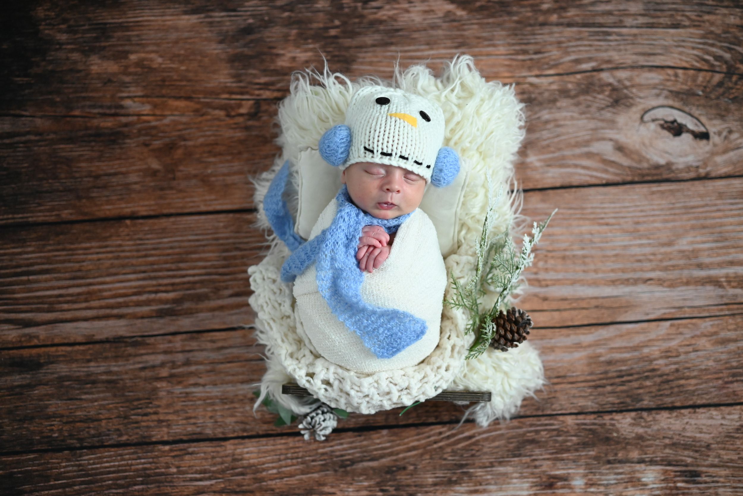 Handmade crochet baby booties in soft blue and white yarn displayed on rustic wooden background.
