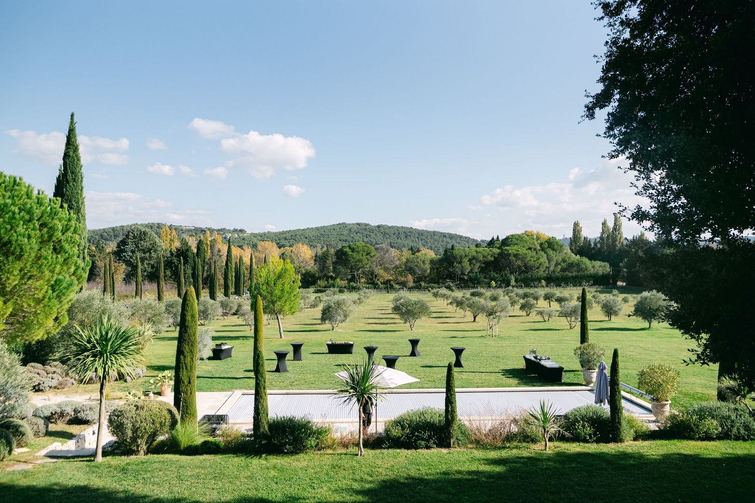 A scenic golf course landscape with rolling hills, cypress trees, and well-maintained fairways stretches into the distance.