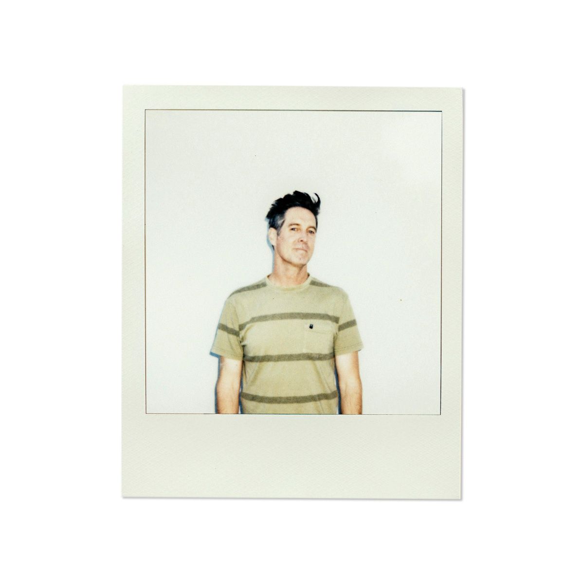 Polaroid portrait of person in striped t-shirt against plain white background.