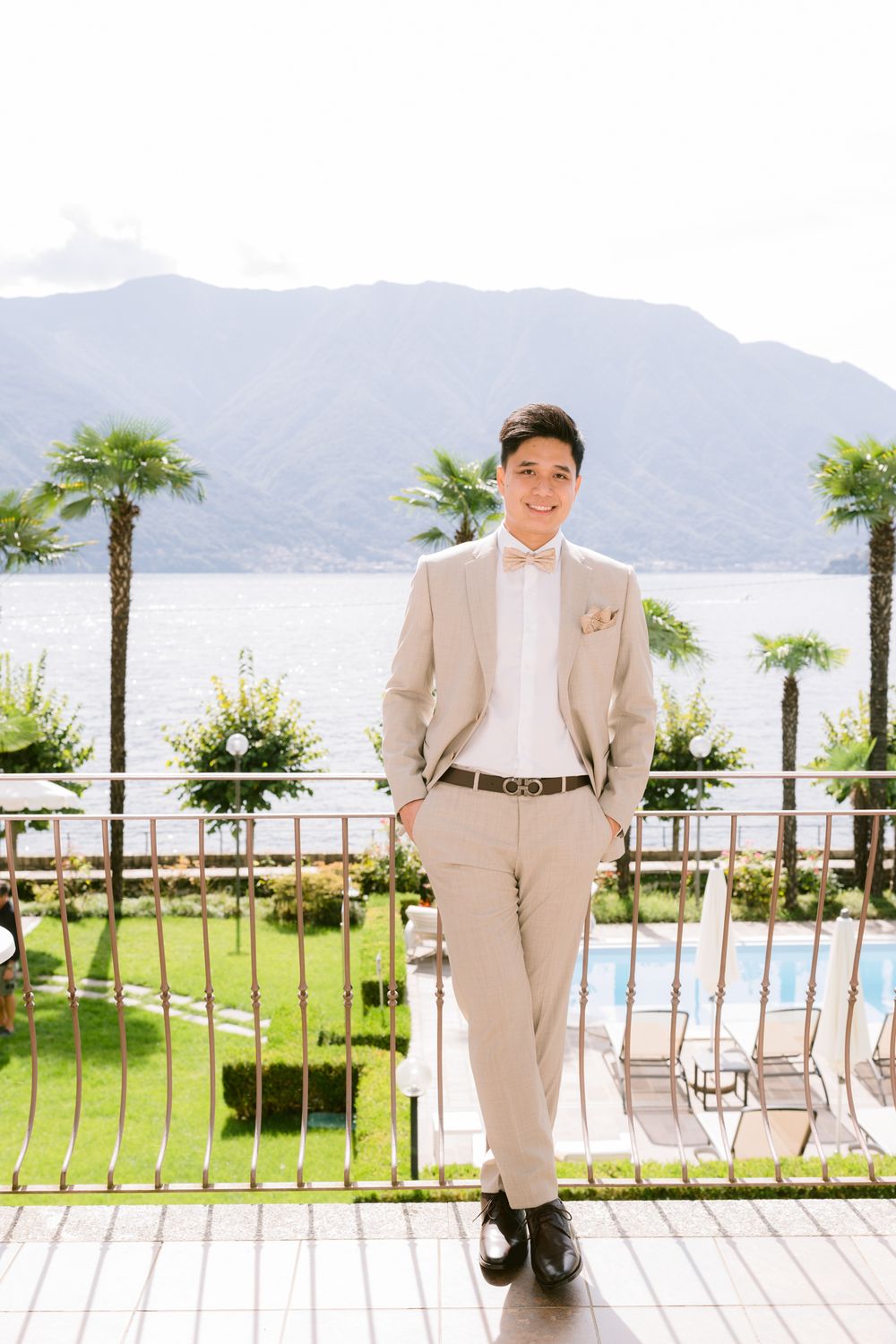 Three photos of a groom in a light beige suit standing at a scenic outdoor venue with mountains and palm trees.