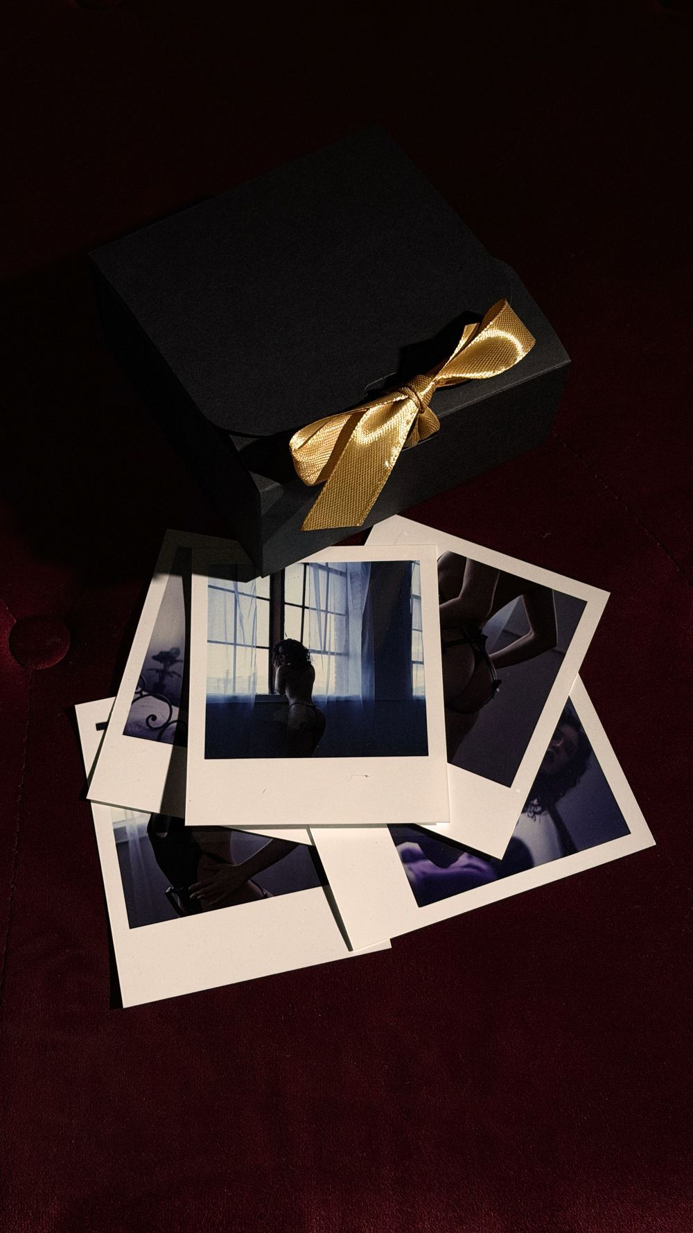 Collection of scattered polaroid photographs against dark background. Light Haus Studio offers luxury wedding, maternity, portrait, and bran