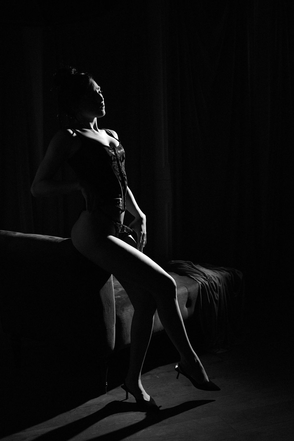 Dramatic black and white boudoir photos with strong contrast lighting.