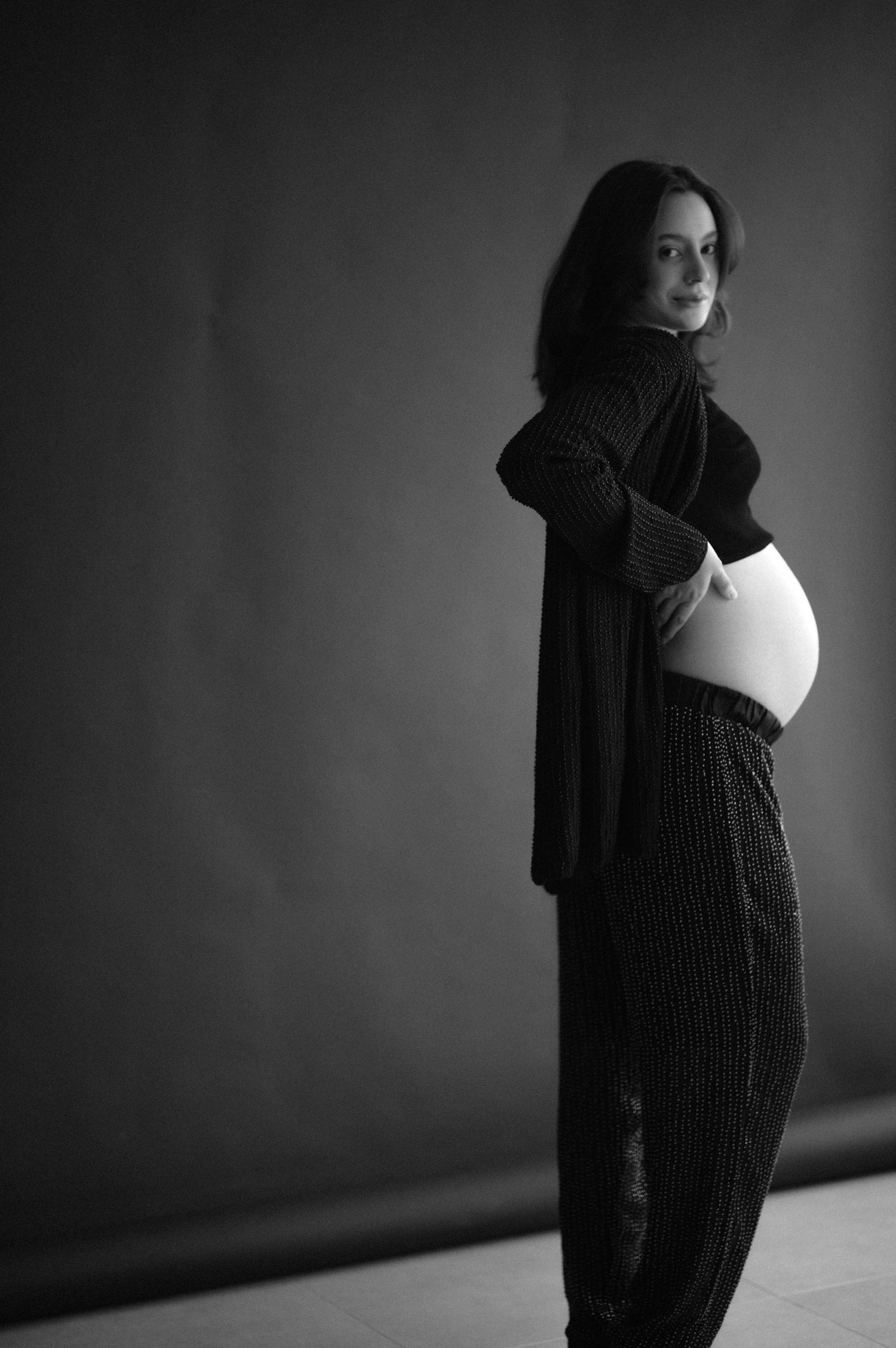 A dramatic black and white photo series showing a person in dark clothing against a shadowy background.
