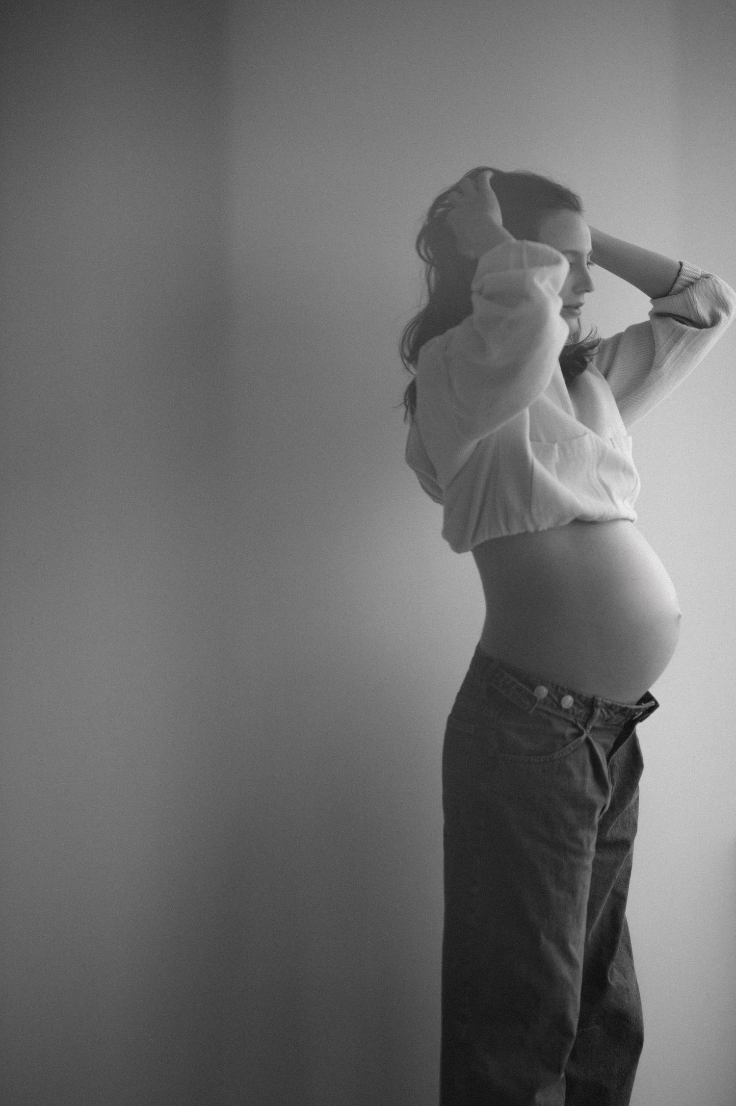 Black and white maternity portraits showing silhouetted poses of an expectant mother against a neutral backdrop.