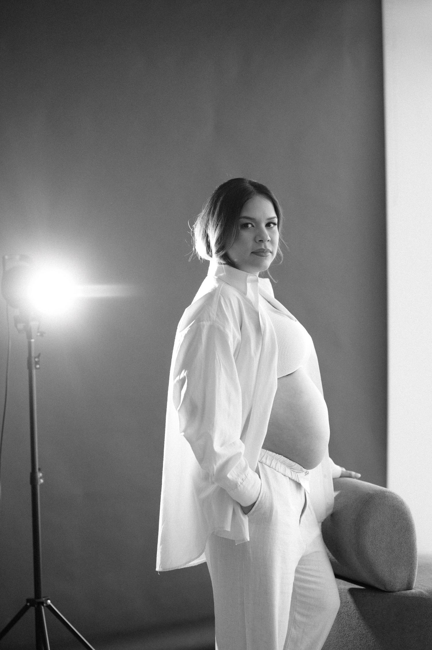 A black and white photo series shows a figure in white clothing posing against a dark background with dramatic lighting.