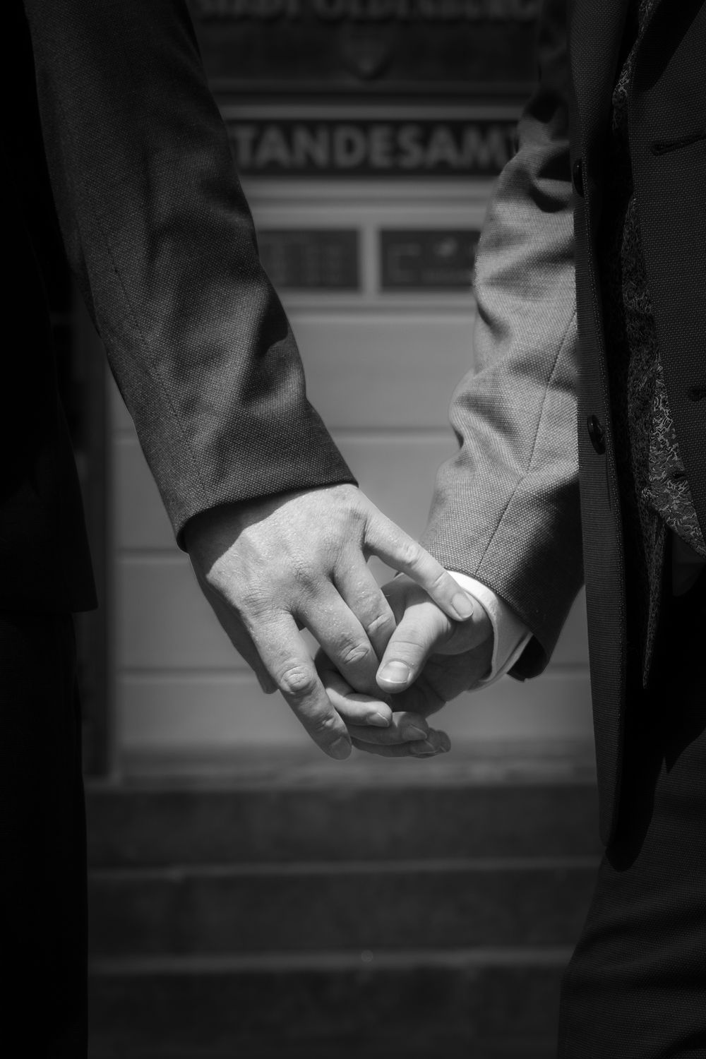 A series of black and white photographs showing two hands clasped together in a holding gesture.