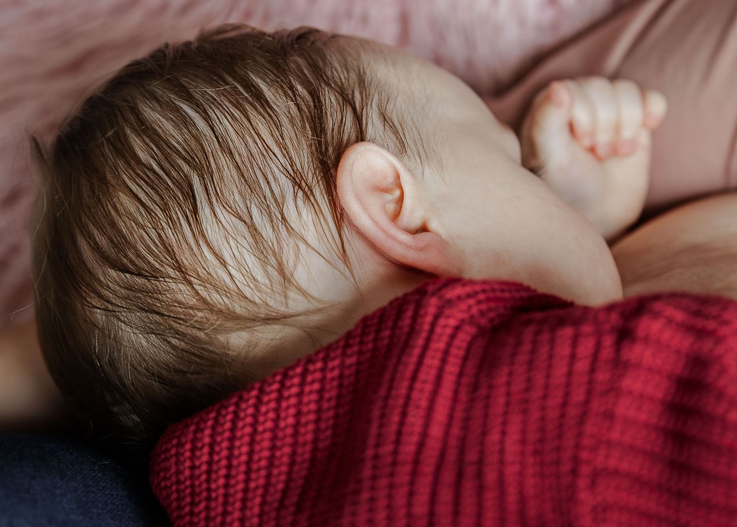 A toddler closes their eyes as they cuddle their mother and breastfeed on the bed. Relaxed and natural Bristol in home baby photoshoot