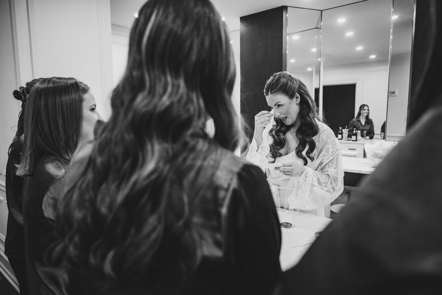 Black and white candid shots capture pre-wedding moments in an elegant room.