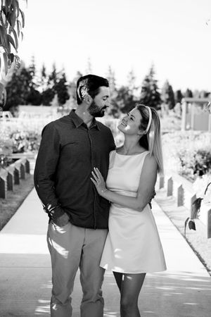 Couple walking and laughing together on a sunny boardwalk in black and white photography.