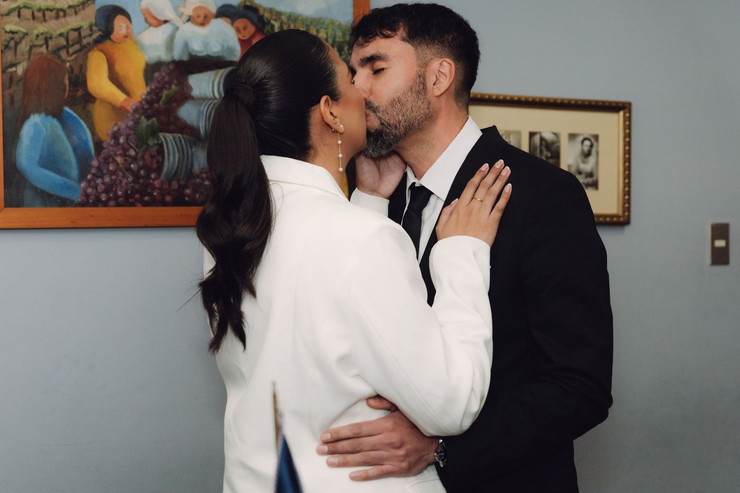 Newlywed couple sharing a kiss during their civil wedding ceremony indoors.