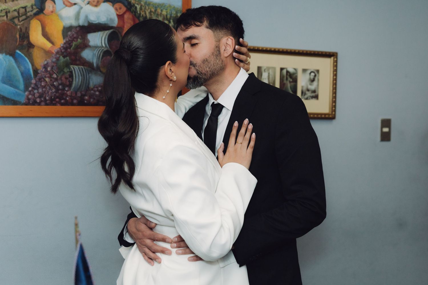 Couple sharing a romantic kiss during their civil wedding ceremony indoors.
