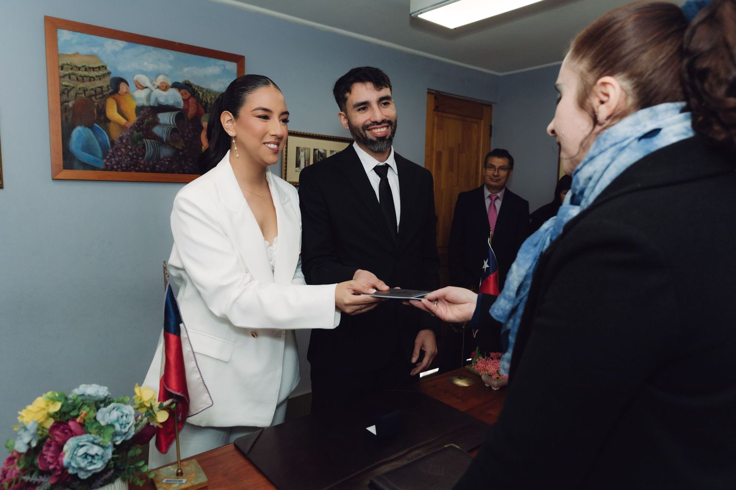 Bride and groom handing documents to officiant at a civil wedding ceremony.
