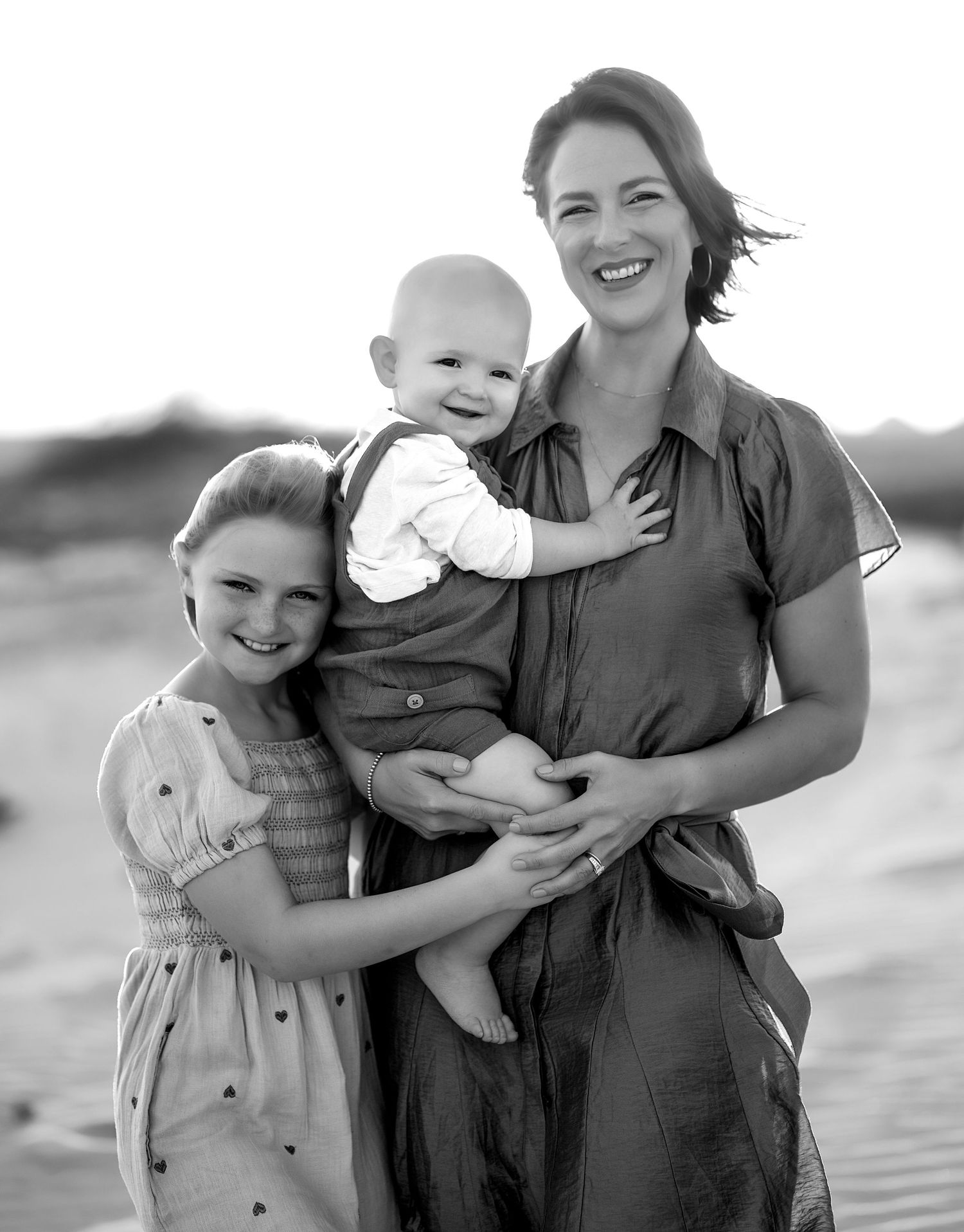 Black and white photo of a mother holding her children on the beach in Matagorda, Texas during a family session