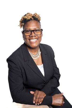 Professional headshot portraits of someone in a black blazer and white top against white background.