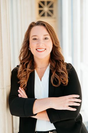 Professional business portrait series showing warm expressions in black blazer and white blouse against light background.