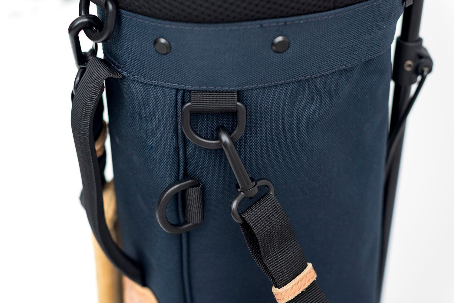 Close-up details of navy blue Charlie Golf Co golf bag hardware showing straps and metal attachments.