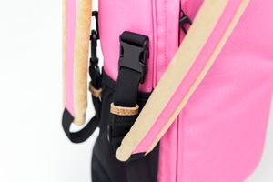 Pink golf bag detail showing black plastic buckle and tan leather straps for product details