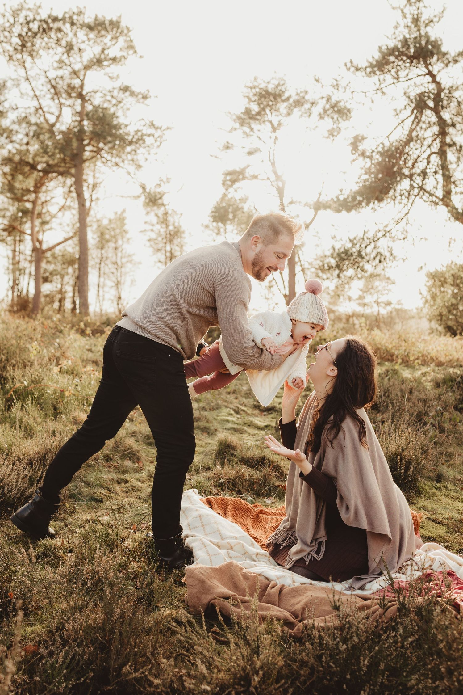 A romantic couple shares tender moments on a hillside at sunset in a series of candid photographs.