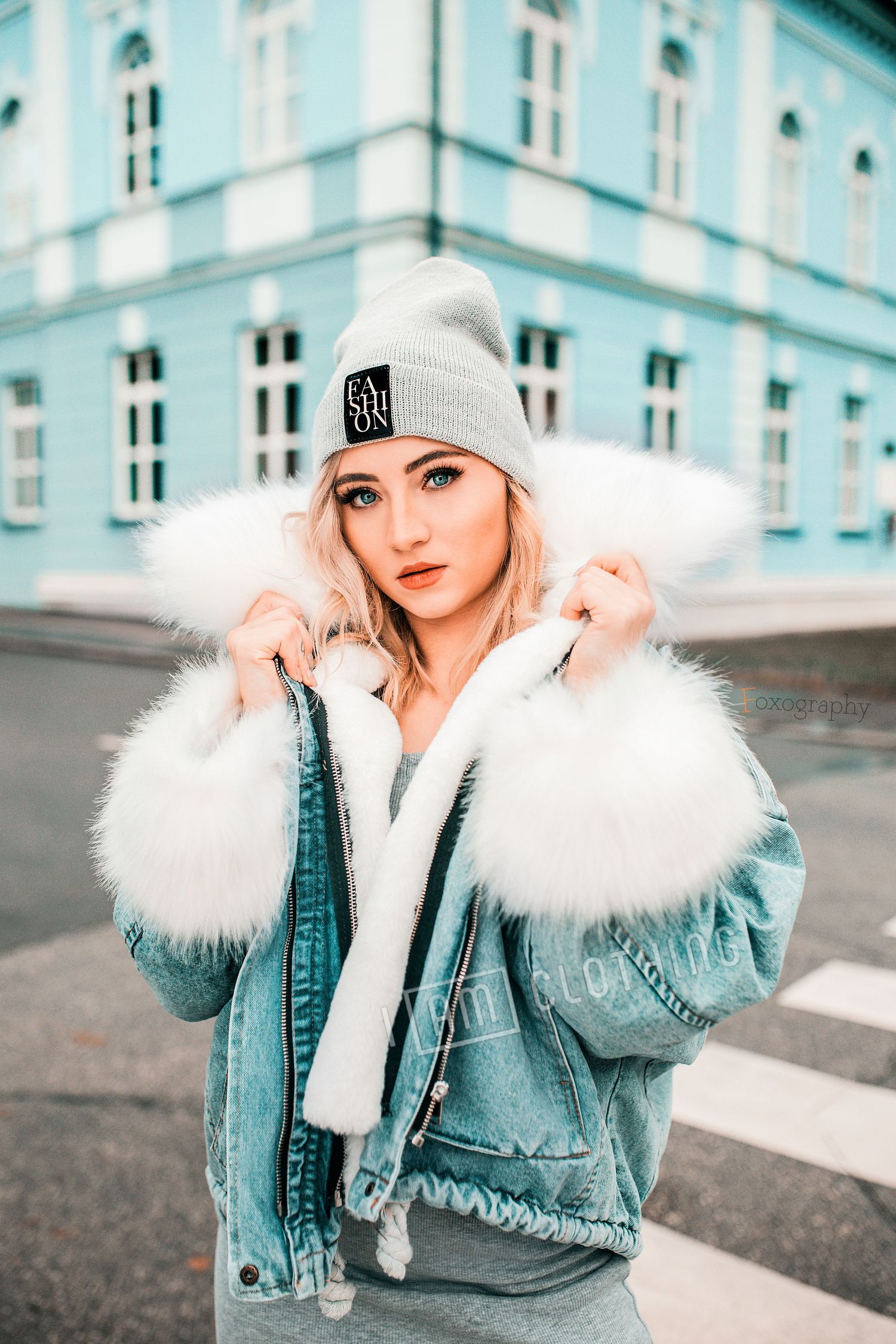 Zimný mestský portrét ženy v džínsovej bunde s kožušinou a čiapkou. Profesionálna lifestyle fotografia v Žiline.