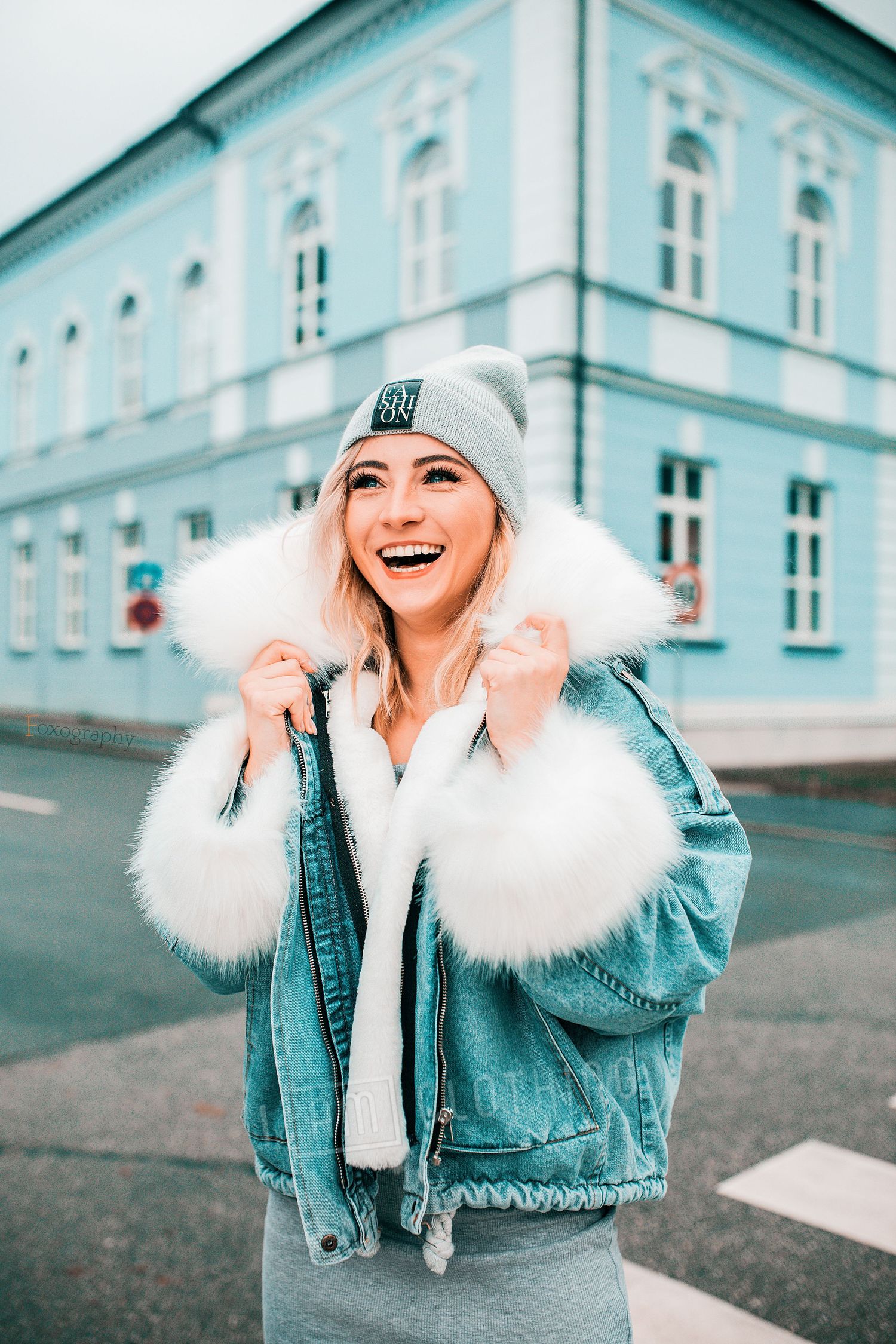Usmievavá blondínka v džínsovej bunde s kožušinou v centre mesta. Autentické lifestylové fotenie, Rajecké Teplice a Žilina.