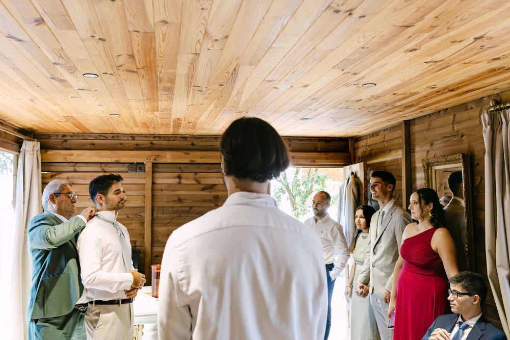 Family gathered around groom before ceremony in Portugal