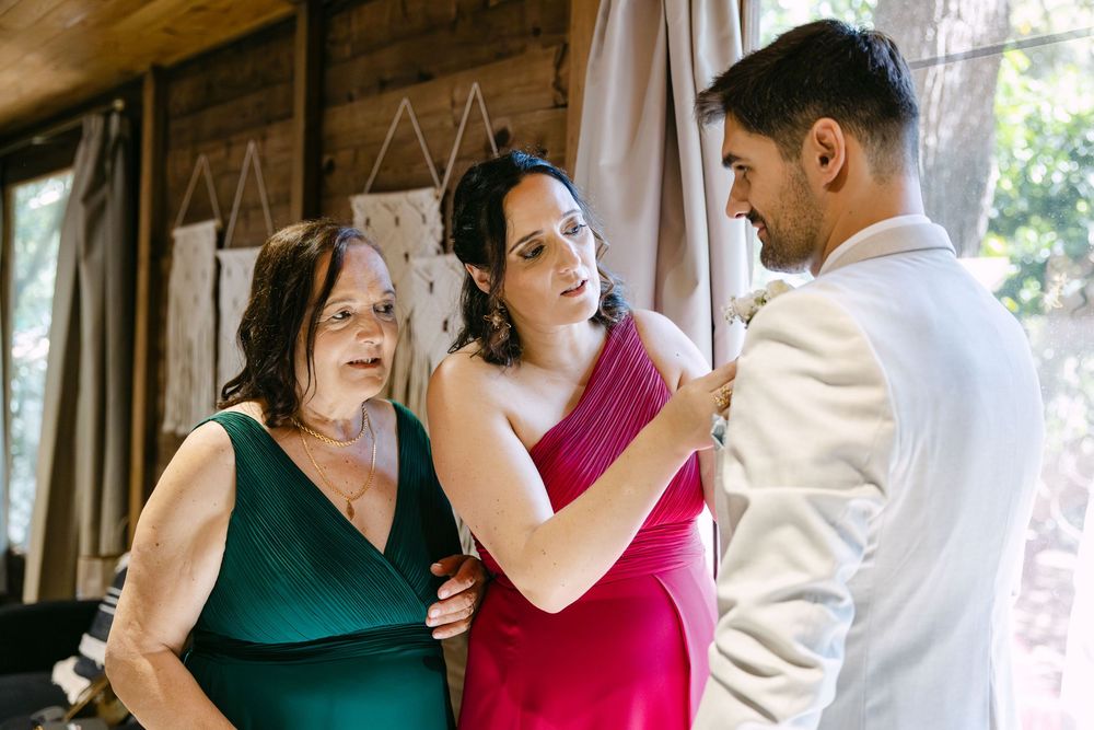 Parents greeting groom before lakeside ceremony