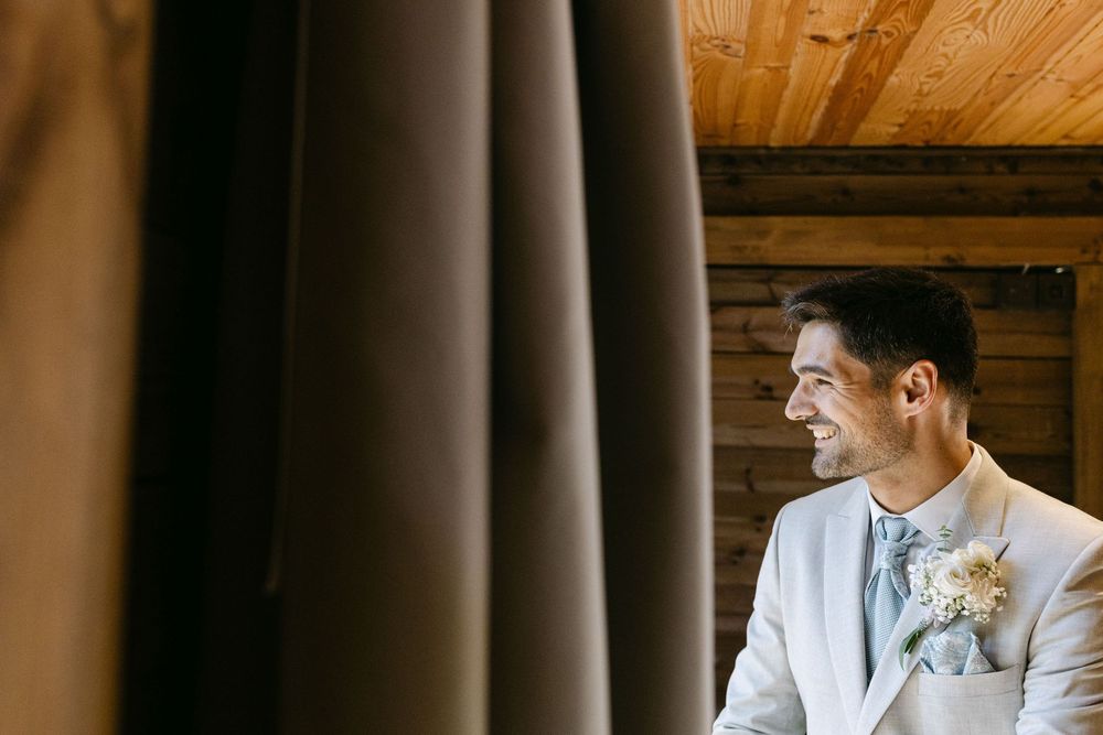 Groom looking out from treehouse before wedding ceremony