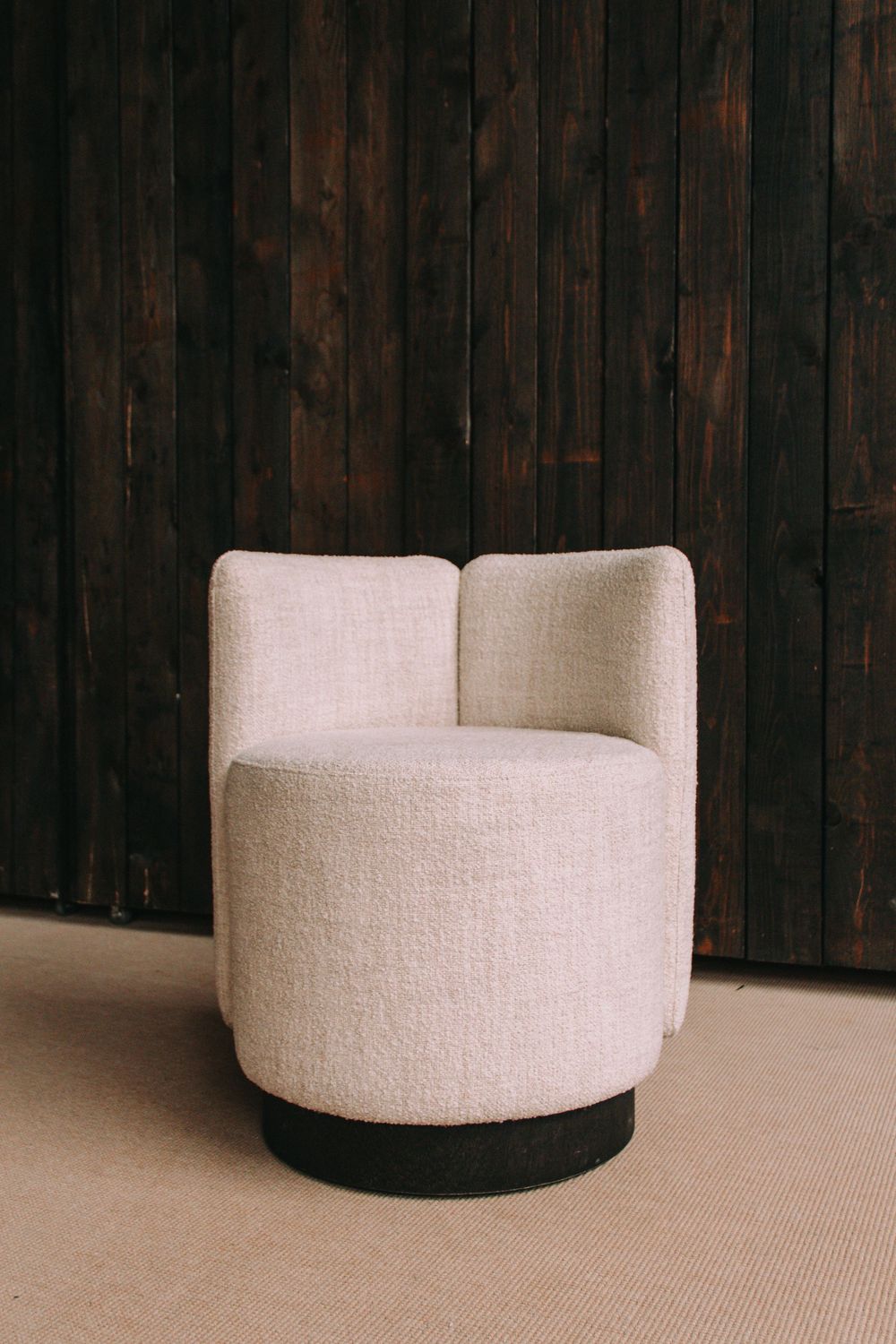 Moderne crèmekleurige fauteuil met ronde vorm in een showroom.
