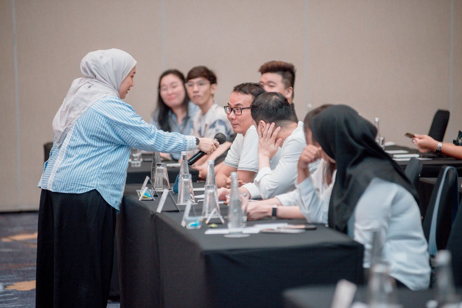 Business professionals collaborating and engaging in discussions during a meeting in a modern office setting.