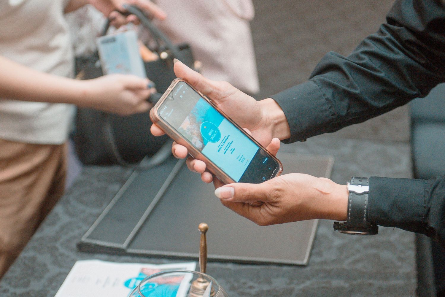 Close up of hands exchanging digital payment through smartphone contactless technology.