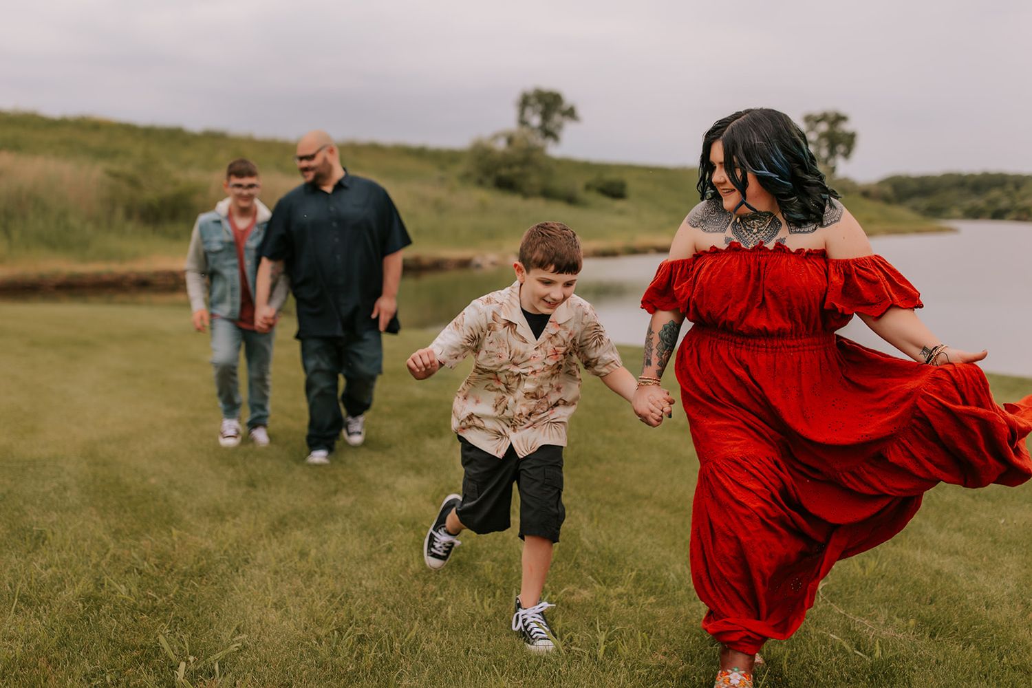 People running and playing together on a grassy field during a joyful outdoor gathering.