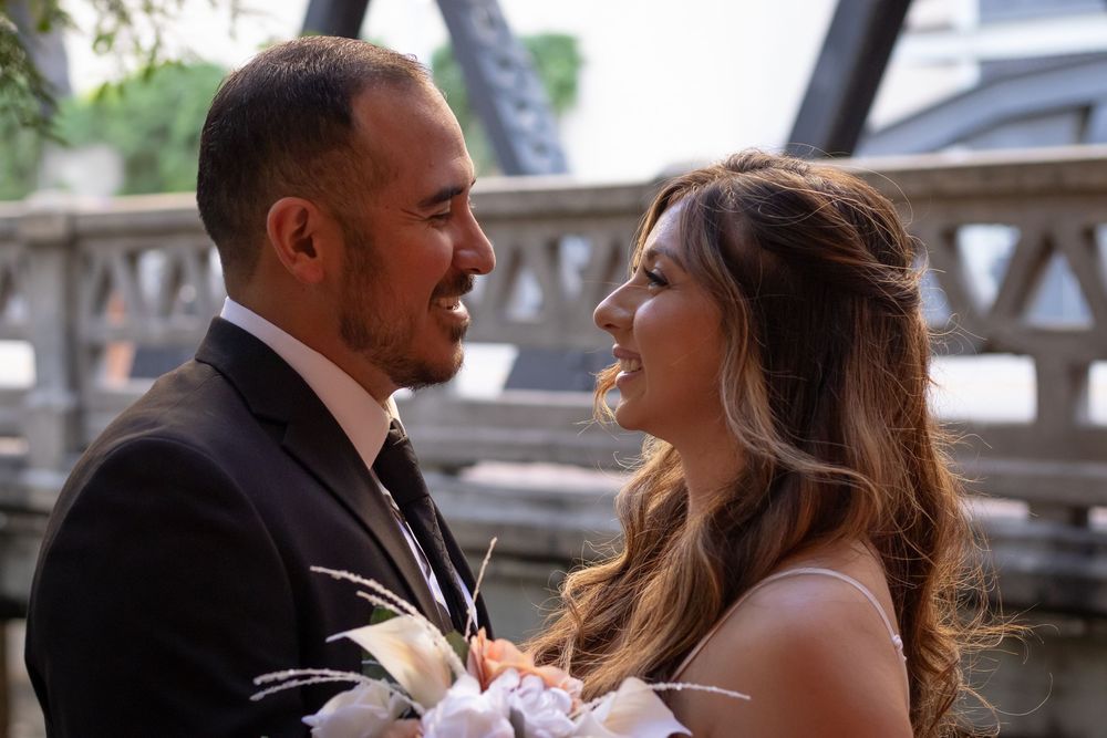 A happy couple sharing a joyful moment together during their outdoor wedding ceremony with soft lighting and flowers.