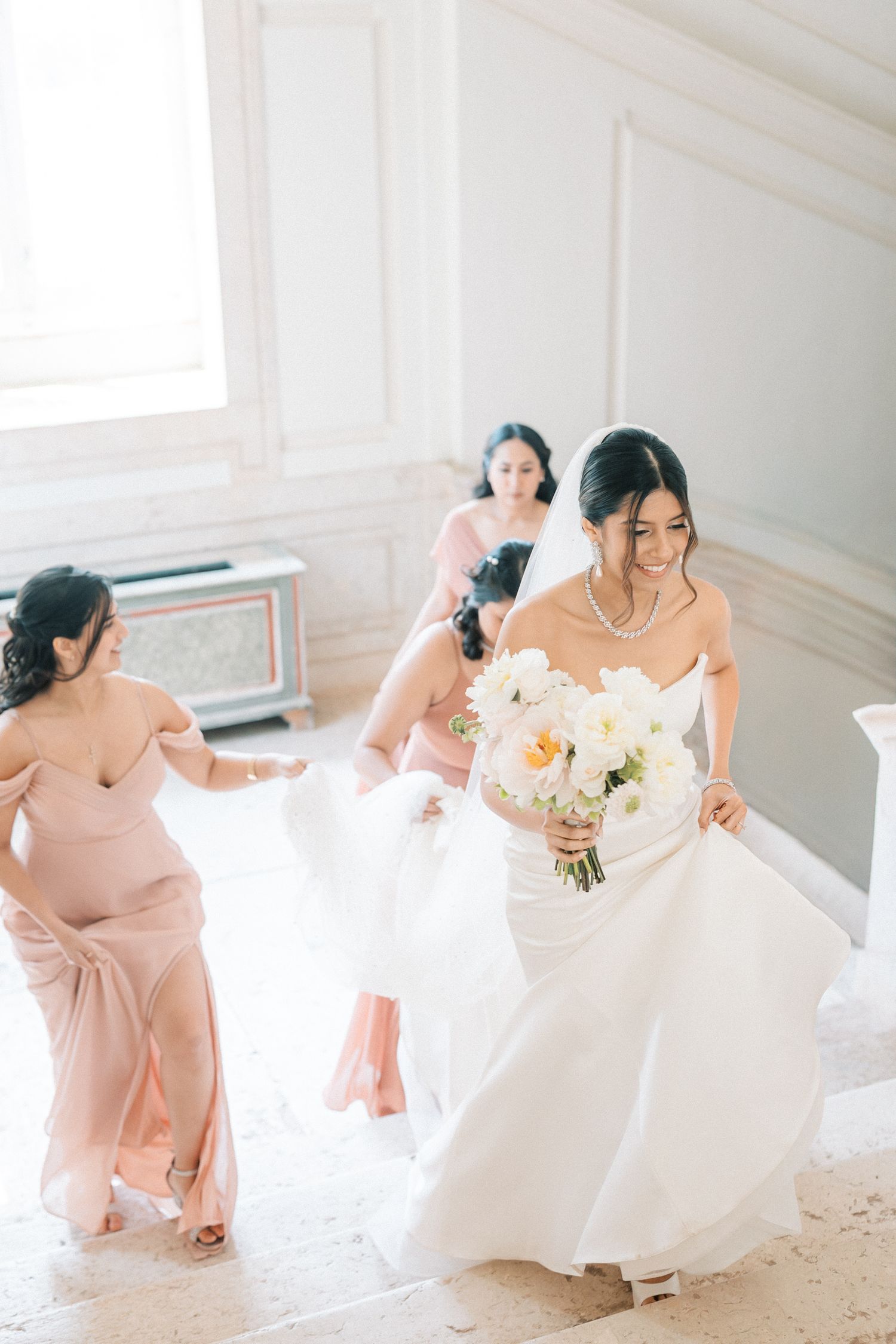 Elegant Indian bride surrounded by bridesmaids during wedding celebration at Palace Correio Mor in Lisbon, Portugal