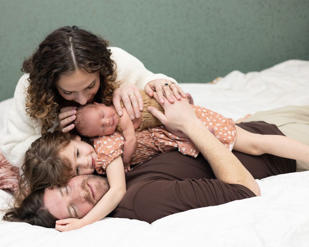 Two children cuddle together while resting on a brown cushion in a tender moment of affection.