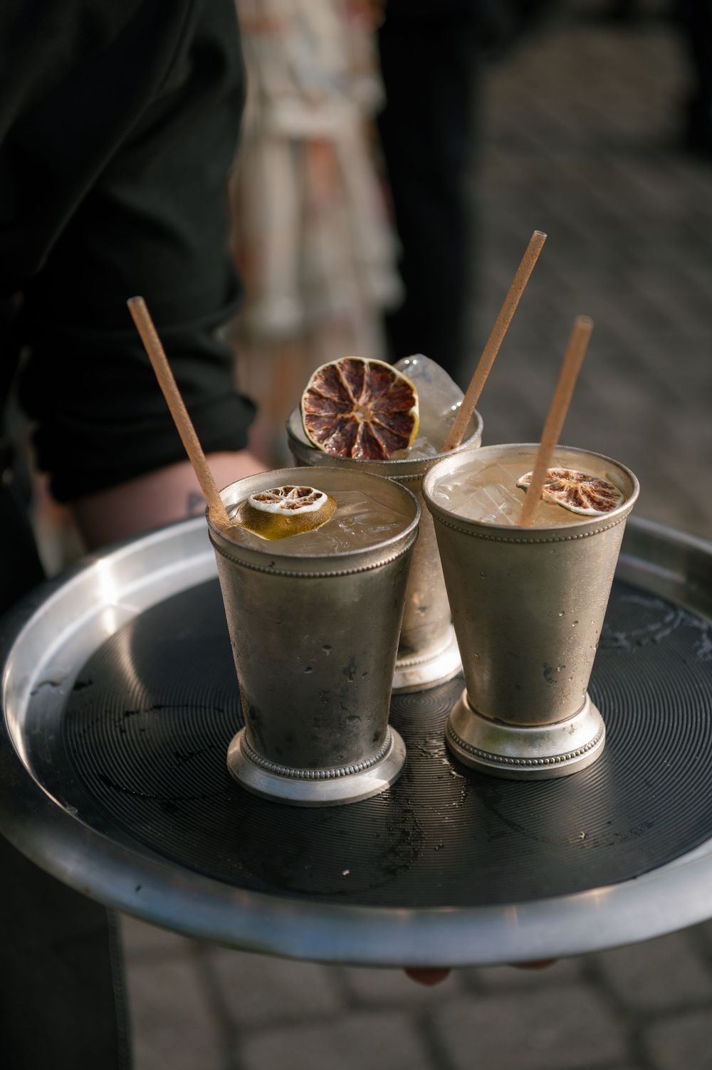 Two elegant milkshakes with citrus garnishes and straws served in silver mint julep cups.