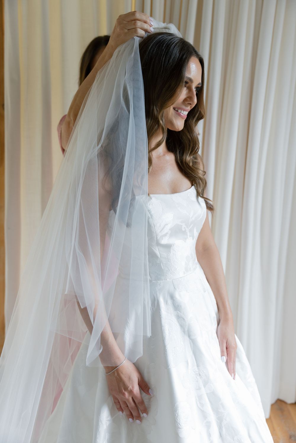 A series of bridal portraits showing a white wedding dress and flowing veil against a light curtained background.