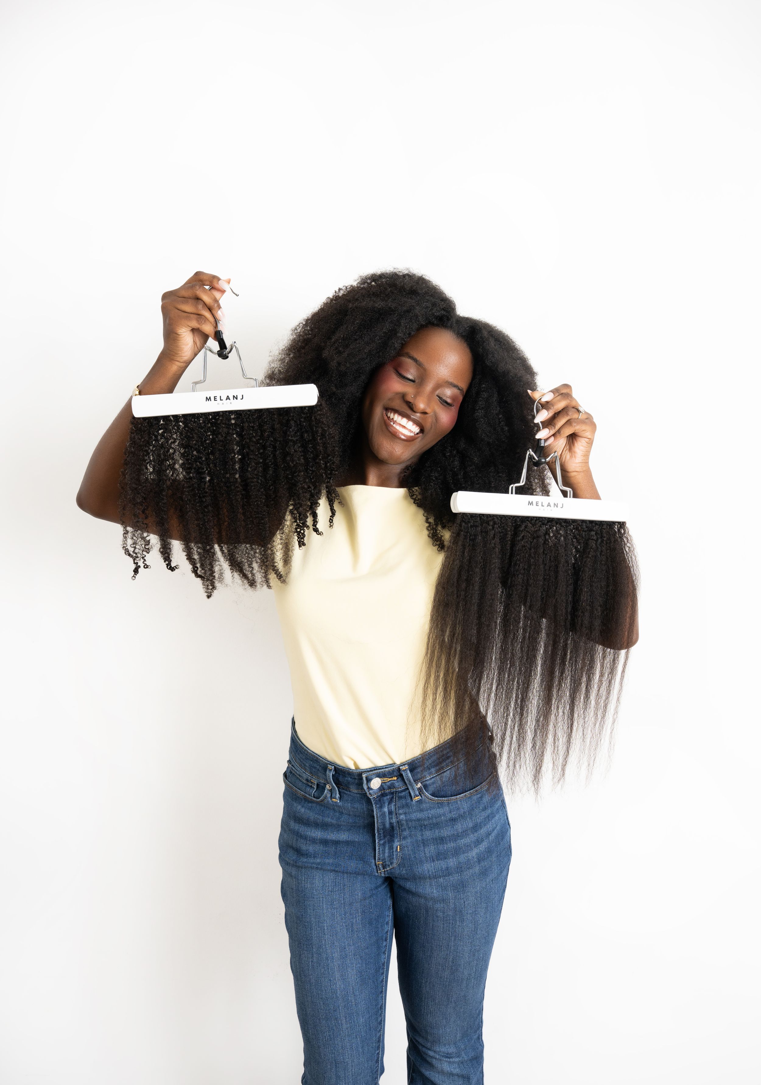Person in yellow top and jeans demonstrates hair length comparison with straight and curly natural hair textures.
