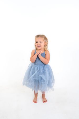 Child in a light blue tulle dress shown in multiple poses against white background.