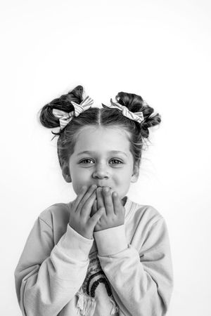 Series of expressive black and white portraits showing children with playful emotions for white studio portrait session.