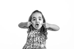 Black and white series of expressive children's poses showing joyful emotions against a white studio backdrop.