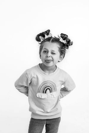 Child making silly expressions against a white studio backdrop for personailty mini session.