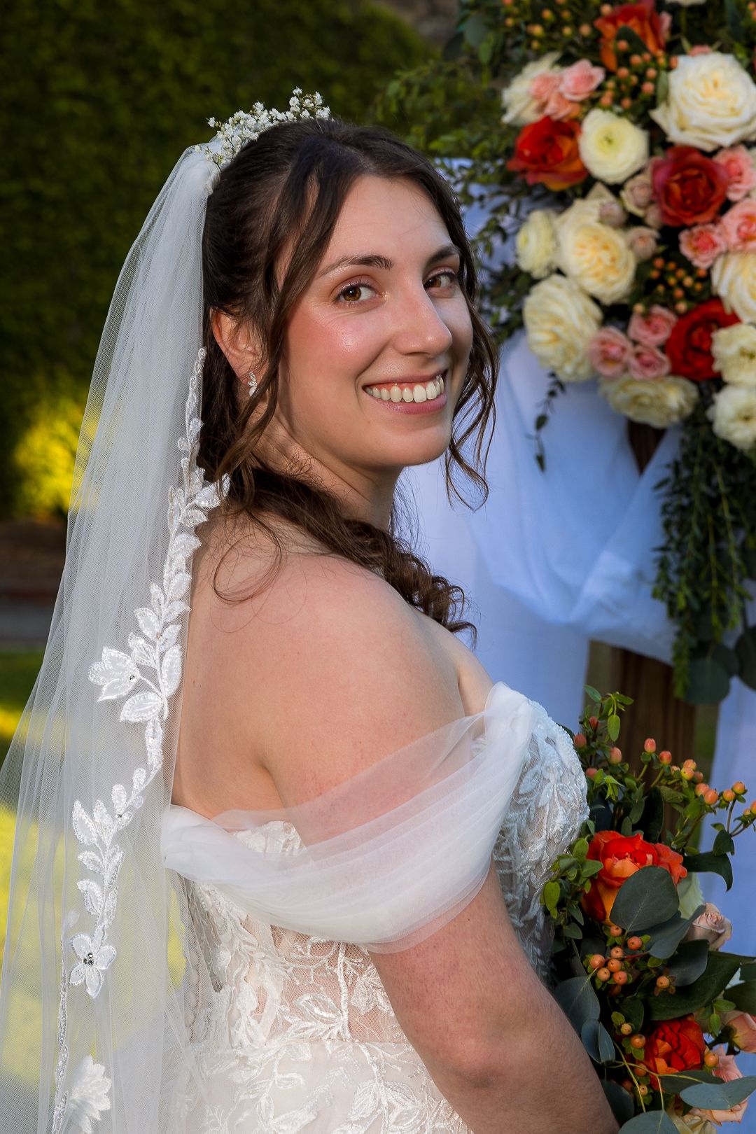 Frederick Maryland Wedding Photographer-  Beautiful floral wedding arch decorated with orange, white and pink roses against autumn backdrop.