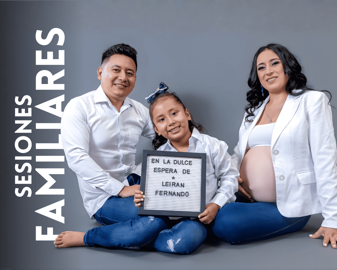 Family maternity photo session with white outfits against grey background showing sign in Spanish.